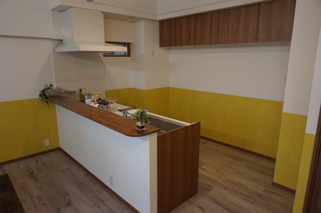黄色と白で貼り分けたキッチン